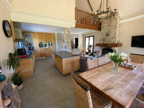 a kitchen and dining room with a wooden table and chairs at La maison normande in Rots