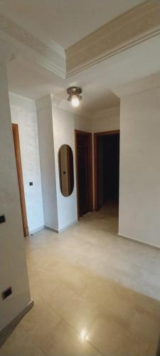 a large empty room with a tv on the wall at Residence Al Kawtar in Mohammedia