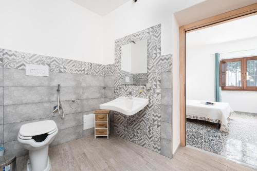 a bathroom with a sink and a toilet at Casa Regina Margherita in Loculi