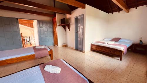 a bedroom with two beds and a window at Aura Hotel Parque Barichara By Infinity in Barichara