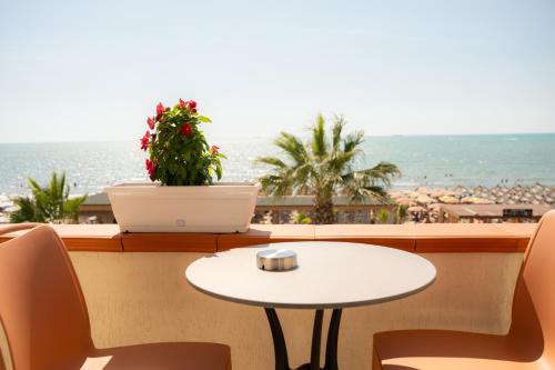 a table with a laptop on a balcony with the beach at Vila Lasko Hotel in Golem