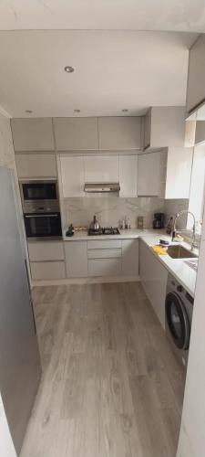 a kitchen with white cabinets and a washer at Residence Al Kawtar in Mohammedia