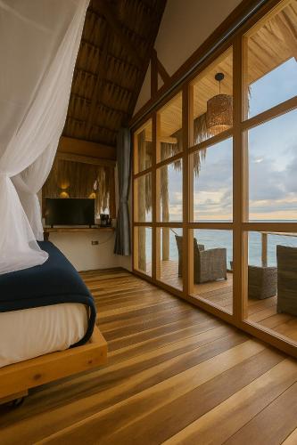a bedroom with a bed and a view of the ocean at RCH LUXURY HOTEL & POOL in Dibulla