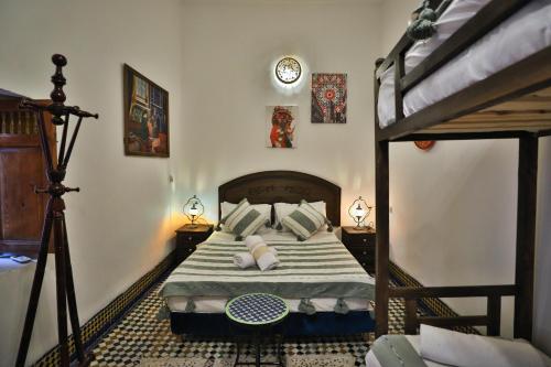 a bedroom with a bed with pillows and a bedsenalsenalsenal at Riad Fes Zayna in Fès