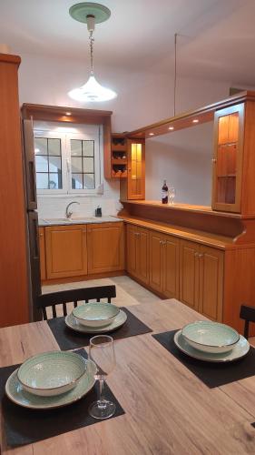 a kitchen with a wooden table with two plates on it at Epiphany Moudros Apartment in Moúdhros