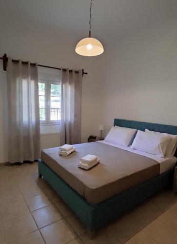 a bedroom with a bed with two towels on it at Epiphany Moudros Apartment in Moúdhros