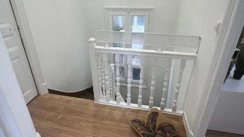a white staircase in a room with a window at 100 m de la mer, Sauna, Wifi in Mers-les-Bains