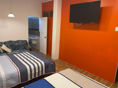 una camera con letto e TV a schermo piatto a parete di Iquitos Confort a Iquitos