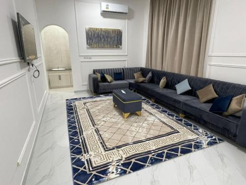 a living room with a blue couch and a rug at Villa awqad salalah in Salalah