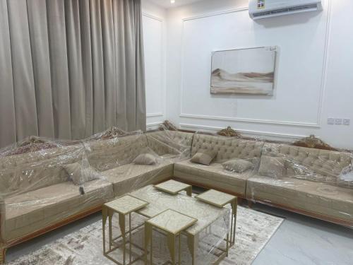 a living room with a couch and two tables at Villa awqad salalah in Salalah