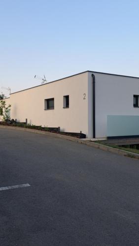 a white building with windows on the side of a road at Wellness Apartmány Panorama in Luhačovice