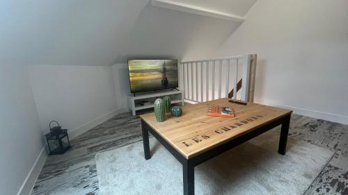 a living room with a table and a television at 100 m de la mer, Sauna, Wifi in Mers-les-Bains