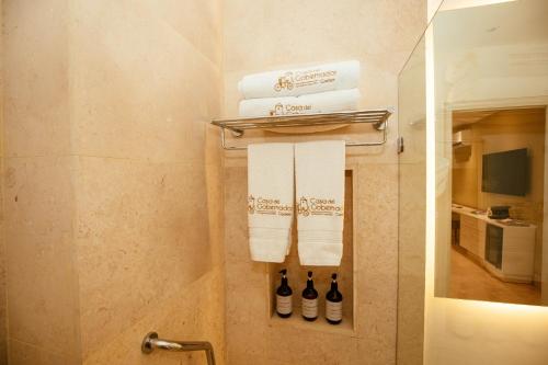 a bathroom with a towel rack with towels at Hotel Casa del Gobernador in Cartagena de Indias