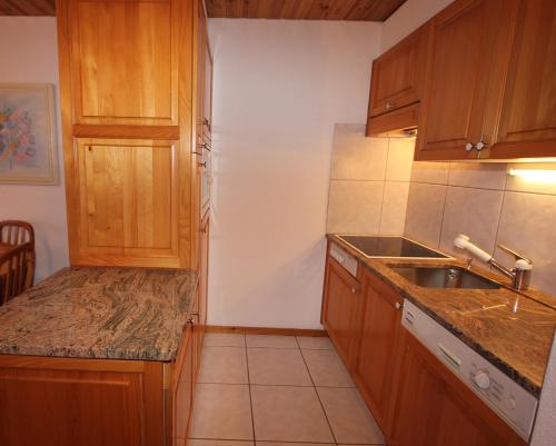 a kitchen with wooden cabinets and a sink at Résidence Mont-Calme in Nendaz
