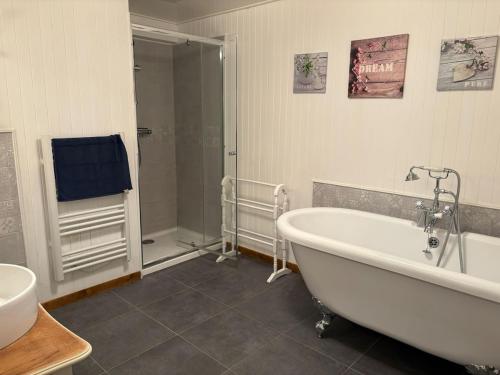une salle de bain avec une baignoire, une douche et un lavabo dans l'établissement Las Coumeilles, à Leychert