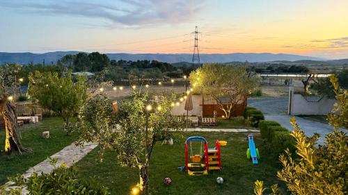 a backyard with an apple tree and a playground at Tringa Guesthouse - Mrizi i Zanave in Fishtë