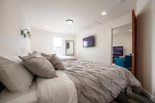 Un dormitorio con una cama grande con almohadas blancas. en Downtown Escape Cozy & Private, en Indianápolis