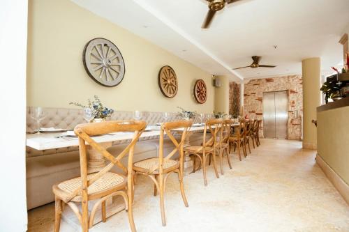 a dining room with a long table and chairs at Hotel Casa del Gobernador in Cartagena de Indias