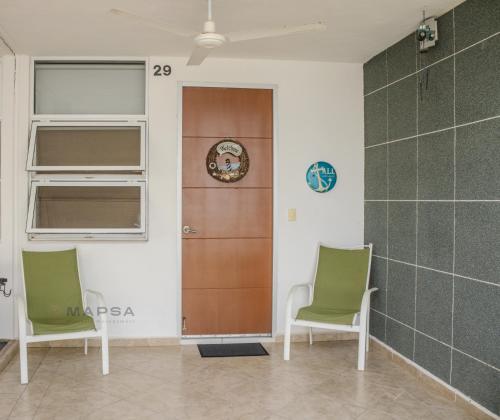 a room with two chairs and a wooden door at Titan 29 Ceibas, Nuevo Vallarta in Jarretadera