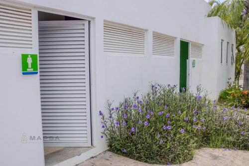 a white building with a door and purple flowers at Titan 29 Ceibas, Nuevo Vallarta in Jarretadera
