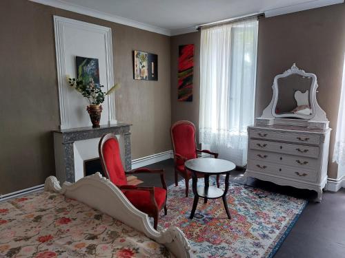 - une chambre avec une table, des chaises et un miroir dans l'établissement Pause Charentaise chambre avec piscine, à Cravans