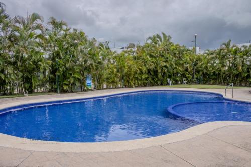 a large blue swimming pool with trees in the background at Titan 29 Ceibas, Nuevo Vallarta in Jarretadera