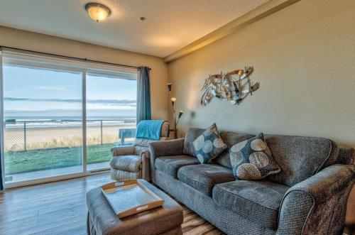 Una sala de estar con un sofá y vista al mar. en Modern Ground Floor Beachfront Condo Suite - Sleeps 4 - Pool and Sauna, en Lincoln City