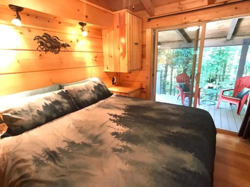 a bedroom with a bed in a log cabin at The Treehouse TN Honeymoon Cabin HOT TUB - in BSF! in Jamestown