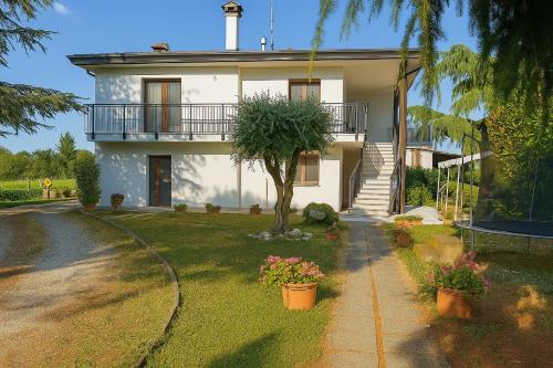 a white house with a tree in the yard at B&B Airport Venice Diego in Tessera