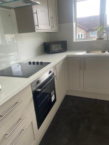 a kitchen with a sink and a stove top oven at Cosy bungalow Branton Doncaster near Yorkshire wildlife park and doncaster centre in Cantley