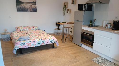 une petite chambre avec un lit et une cuisine dans l'établissement Petit nid douillet, à Fourques