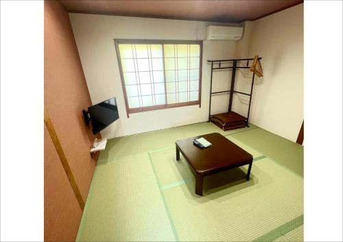 a living room with a table and a window at 民宿食事処 たつのや in Shirahama