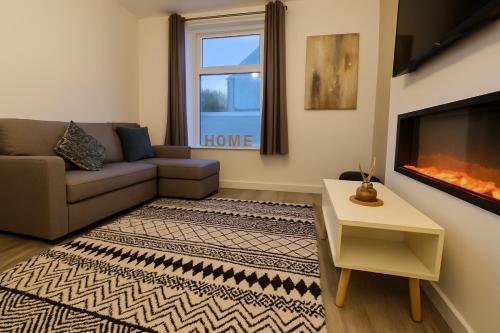 a living room with a couch and a fireplace at New Stylish Modern Home & Free Parking! in Darwen