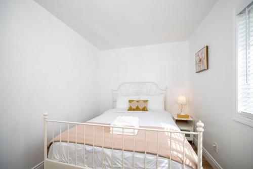 a white bedroom with a white bed with a white bed frame at Cozy 2BR2BA Guest House in Alhambra in Alhambra