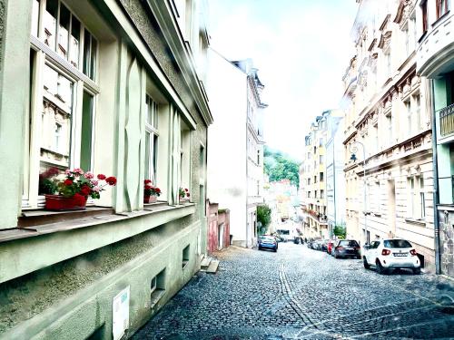 a city street with buildings and a car parked on the street at Oasis Valley in Karlovy Vary