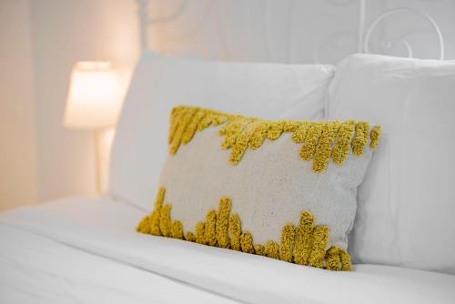 a yellow pillow on a white bed with a lamp at Cozy 2BR2BA Guest House in Alhambra in Alhambra