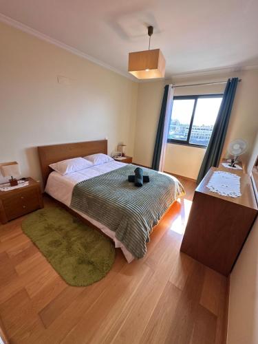a bedroom with a bed and a large window at Heart of Madeira in Funchal