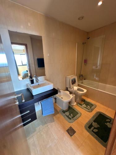 a bathroom with a sink and a toilet and a tub at Heart of Madeira in Funchal