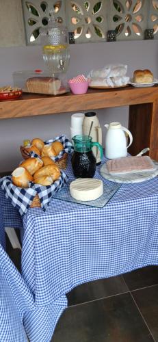 un tavolo con panno da tavola blu e bianco con pane di Espaço Villa Pella - Chalé Jasmim a Piedade do Paraopeba