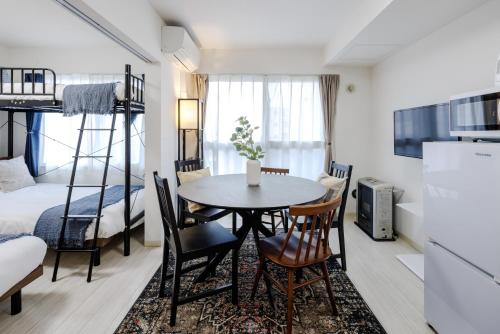 a small room with a table and chairs and a bed at Hotel Hs Park Chitose in Chitose