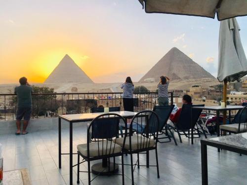 a group of people sitting at tables looking at the pyramids at Pyramids View Inn in Cairo