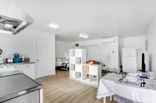 a kitchen with white cabinets and a table in a room at Cozy Guesthouse near Downtown Alhambra in Alhambra
