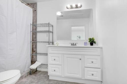a white bathroom with a sink and a toilet at Cozy Guesthouse near Downtown Alhambra in Alhambra