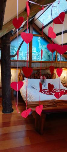 a room with red hearts hanging from a bed at Cabaña en la Calera Cerezos in La Calera