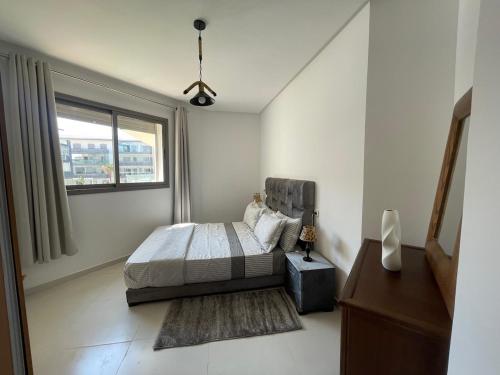 a bedroom with a bed and a window at Cosy apartment in Bouznika in Bouznika