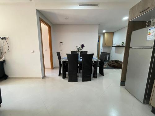 a dining room with a table and black chairs at Cosy apartment in Bouznika in Bouznika