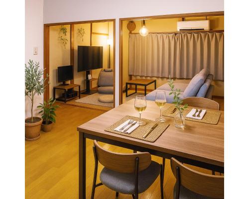 a living room with a dining room table with wine glasses at Harbor Nook Takamatsu in Takamatsu