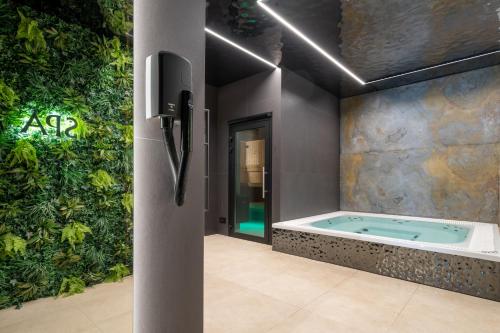 a jacuzzi tub in a bathroom with a green wall at TATRAHOLIDAY - Apartament Mountain Pool & Spa in Białka Tatrzanska