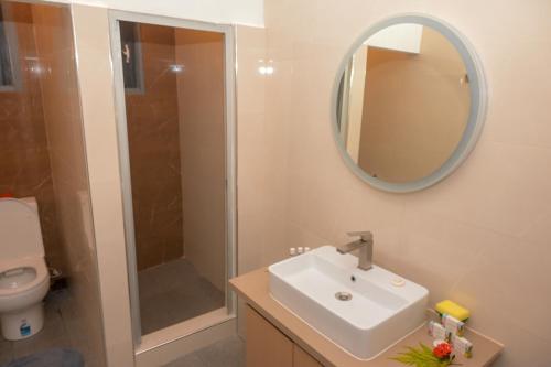 un bagno con lavandino, doccia e specchio di Grand Melanesian Resort Wailoaloa a Nadi