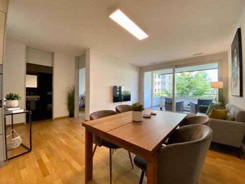 a living room with a wooden table and chairs at Stadtwohnung beim Albisriederplatz in Zürich